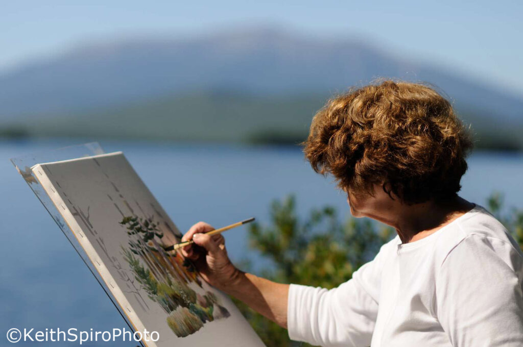 Artist Evelyn Dunphy at work painting in a photo by Keith Spiro